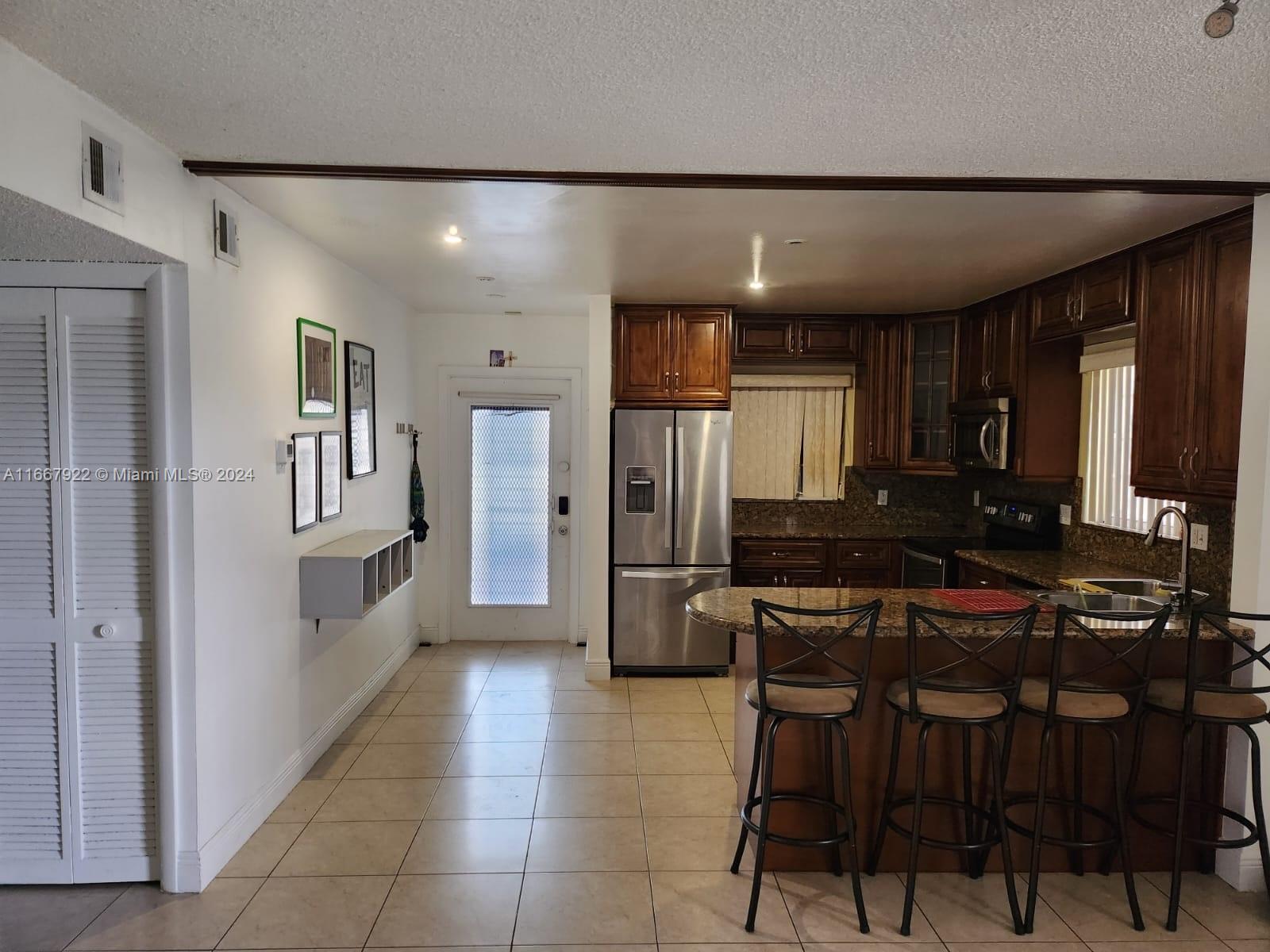 a kitchen with stainless steel appliances a refrigerator and a stove top oven