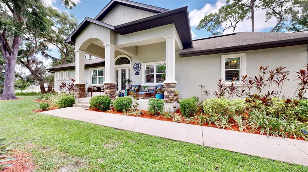 front view of house with a yard and potted plants