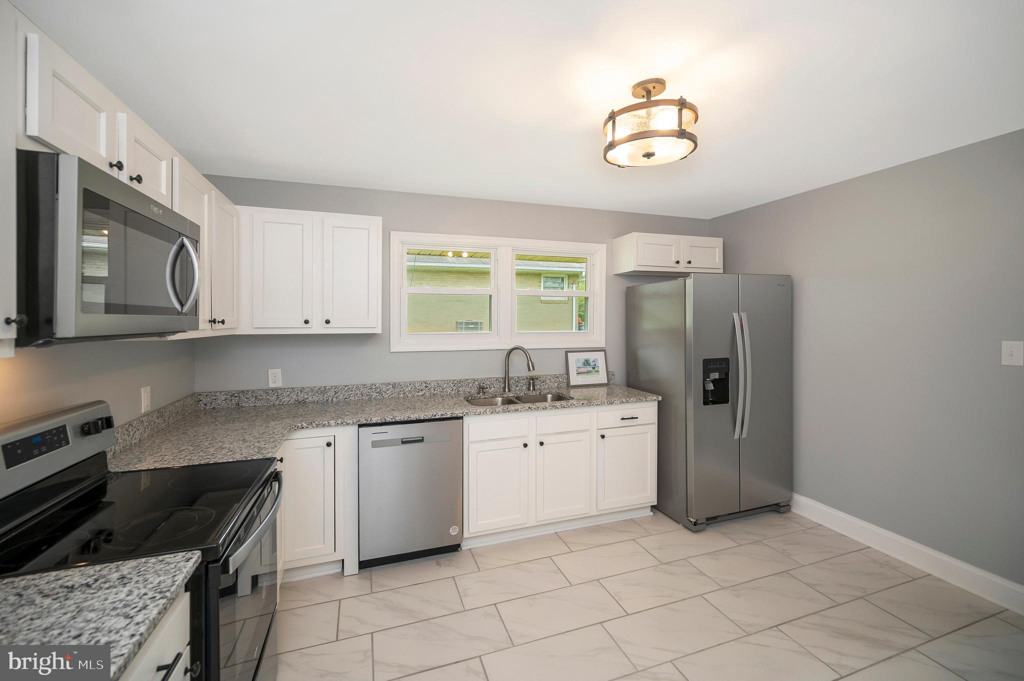 a kitchen with stainless steel appliances granite countertop a stove a sink dishwasher and a refrigerator