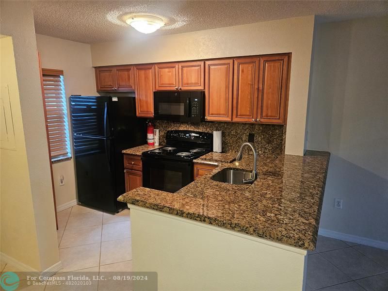 a kitchen with stainless steel appliances granite countertop a refrigerator stove and oven