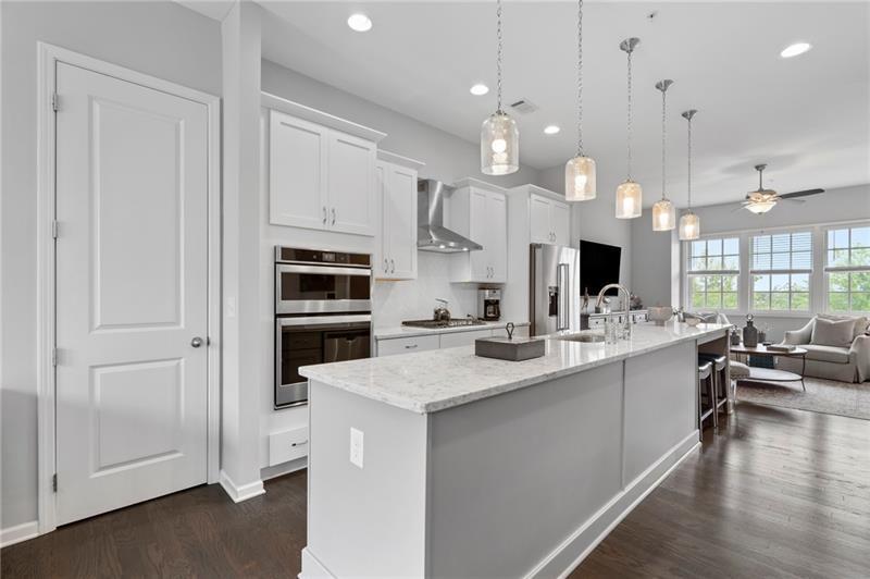 a kitchen with stainless steel appliances kitchen island granite countertop a sink and a refrigerator