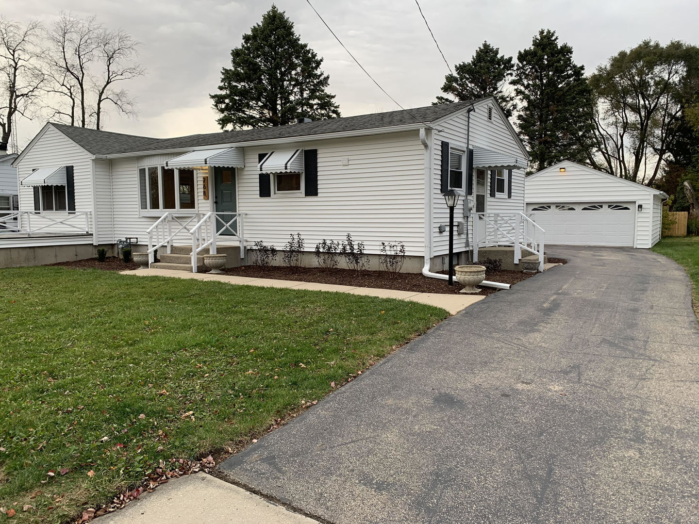 a front view of a house with a yard and trees