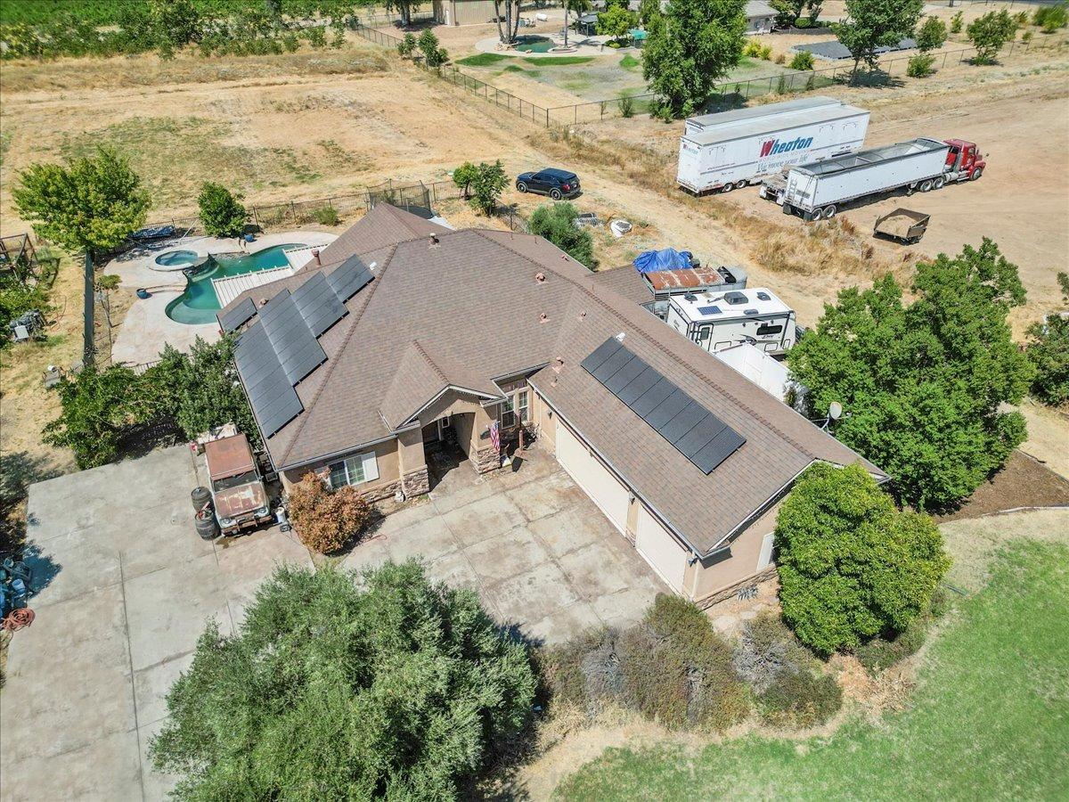 an aerial view of a house with yard and seating space