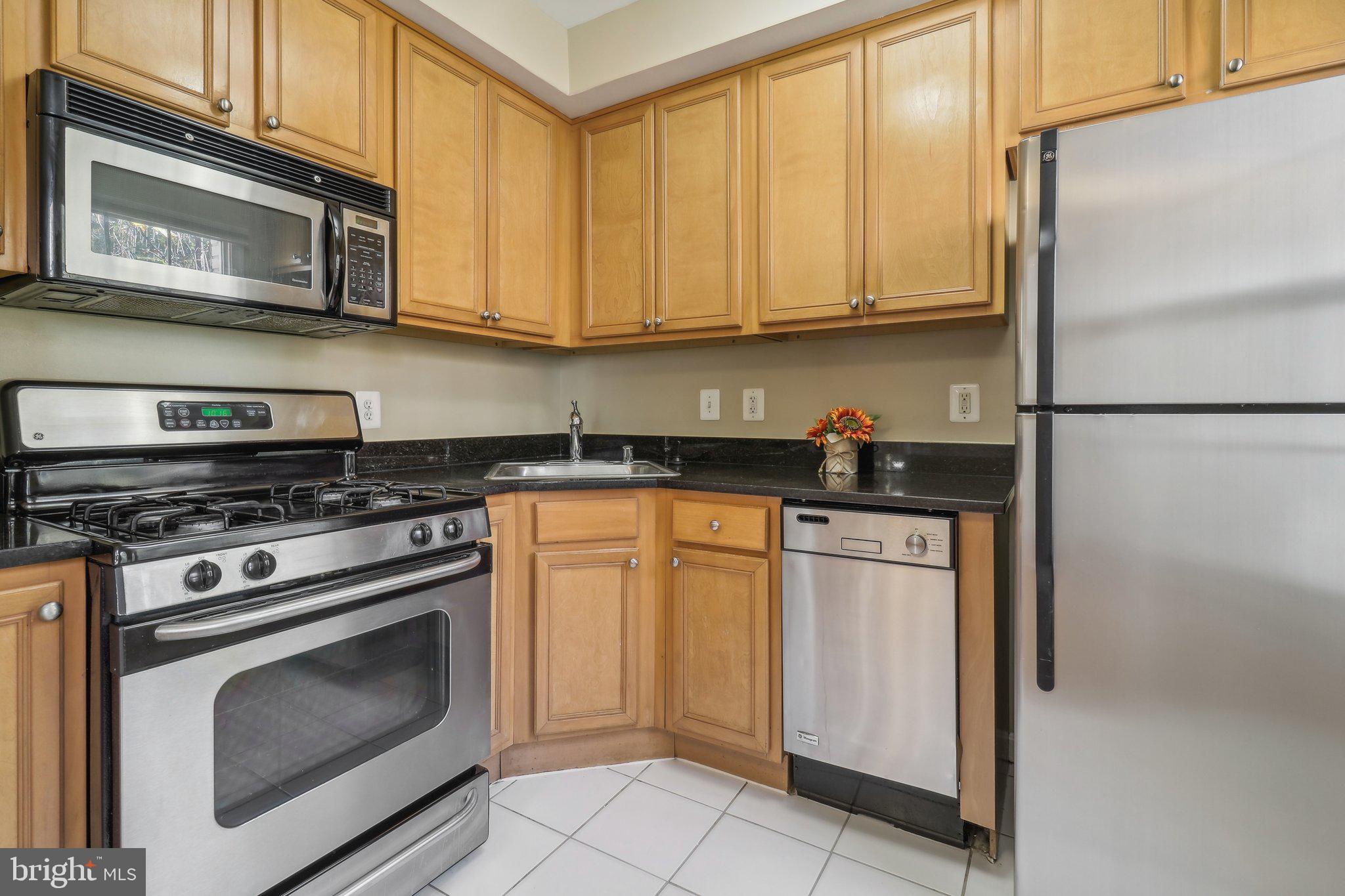 a kitchen with stainless steel appliances granite countertop a stove a refrigerator and a microwave