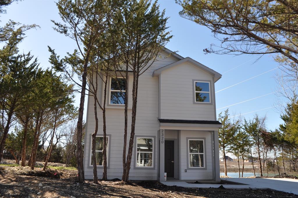 a front view of a house with a tree