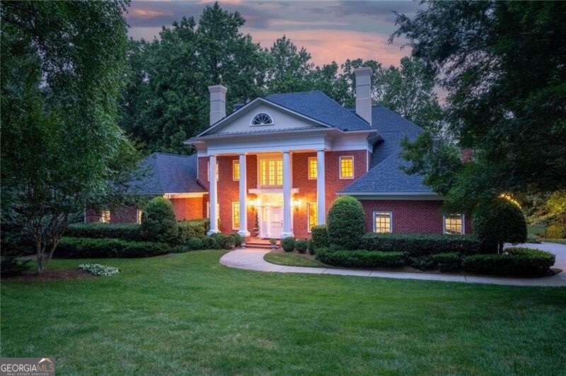 a front view of a house with a yard and green space