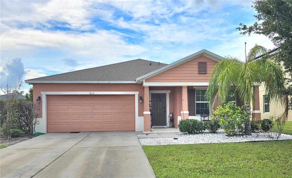 a front view of a house with a yard and garage