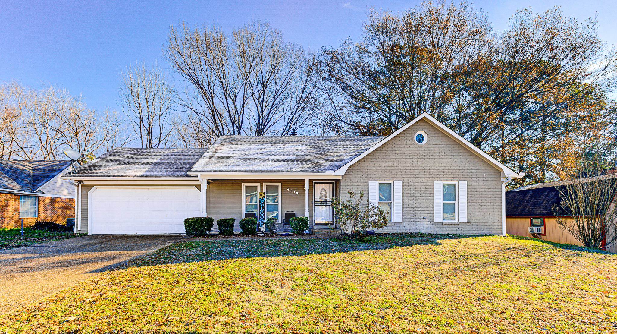 View of front of home with a garage, covered porch, and a front yard