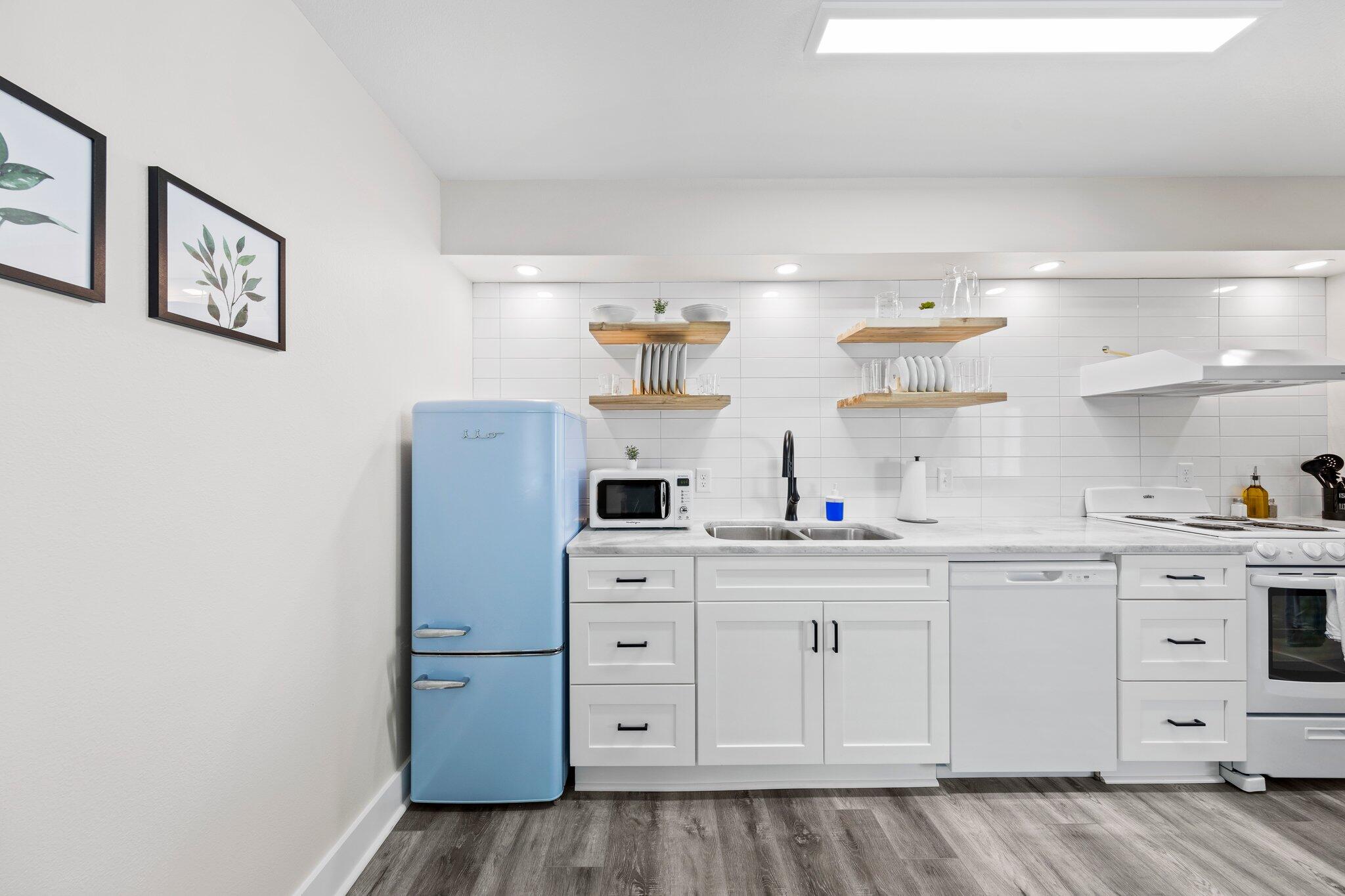 a kitchen with cabinets appliances and a wooden floor