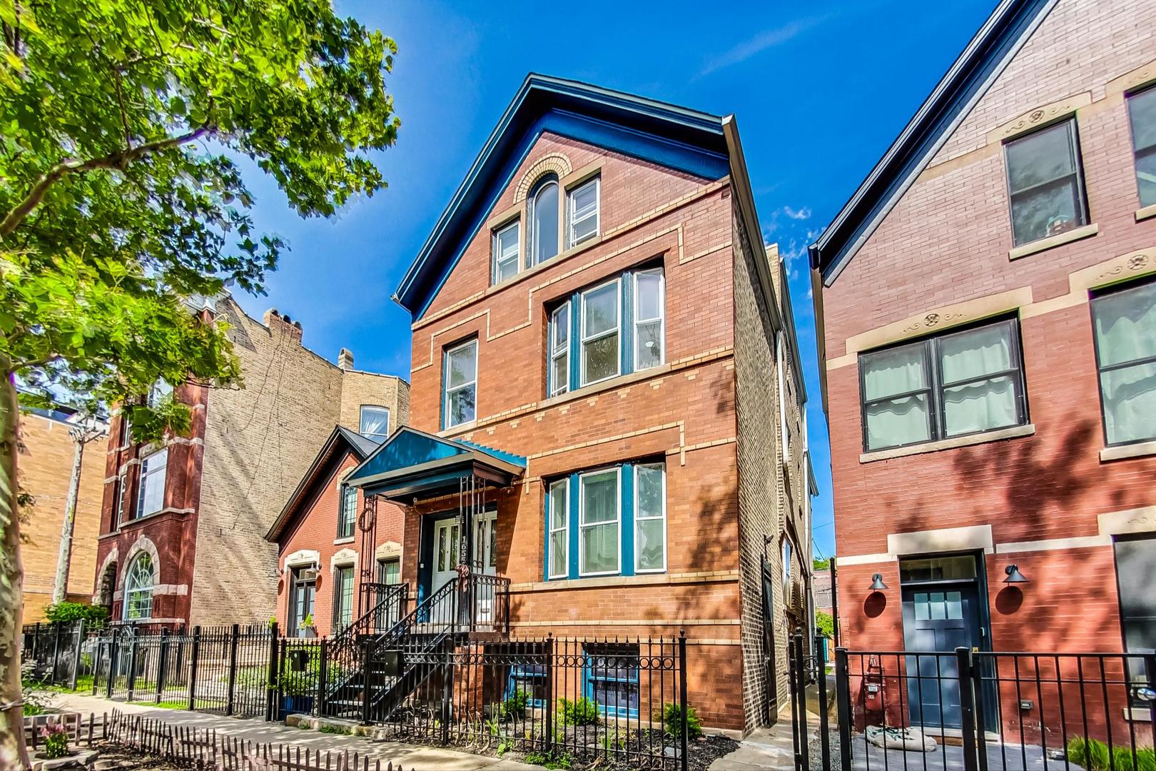 a front view of a residential apartment building with a yard