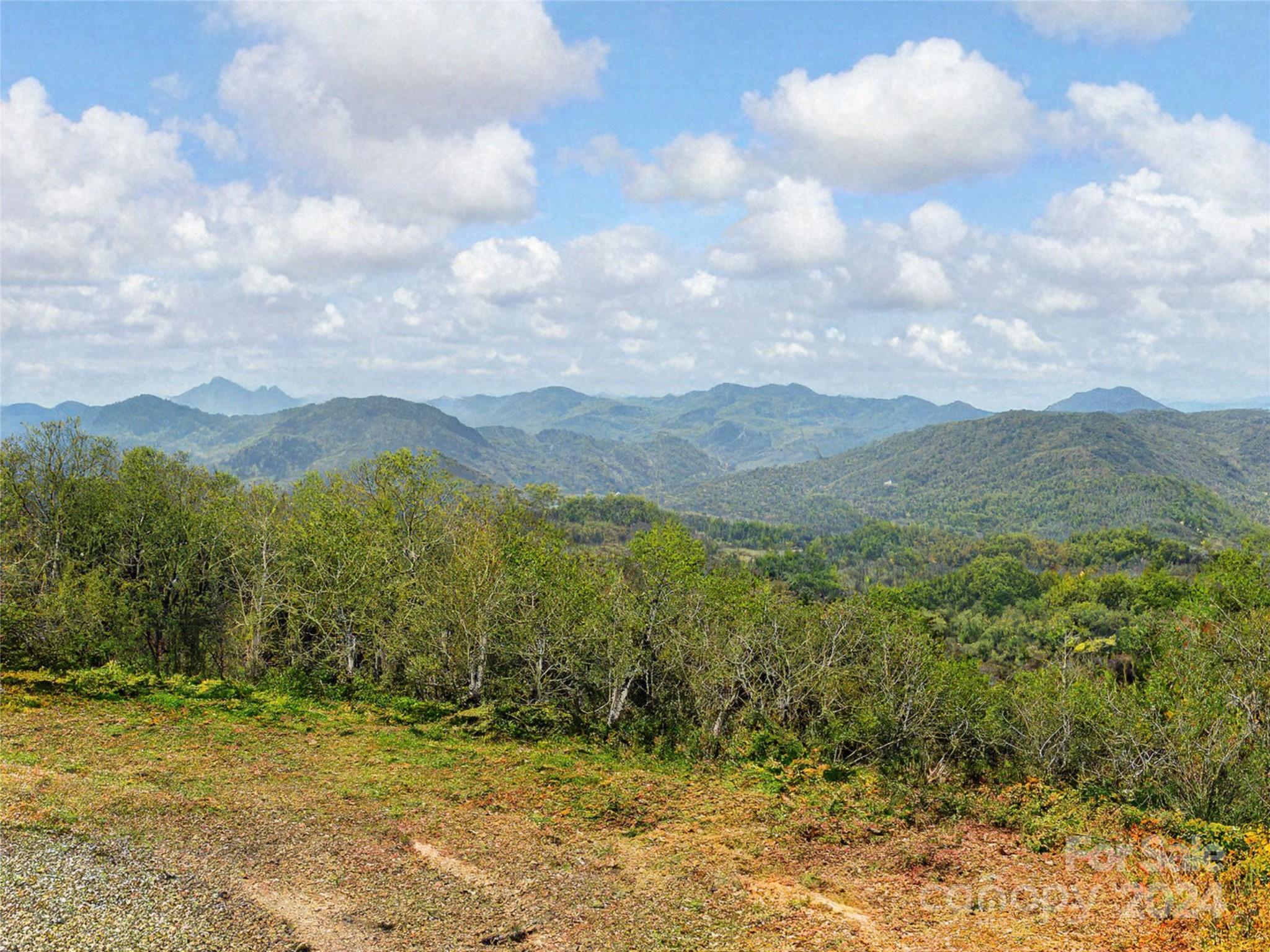 a view of a field with mountains in the background