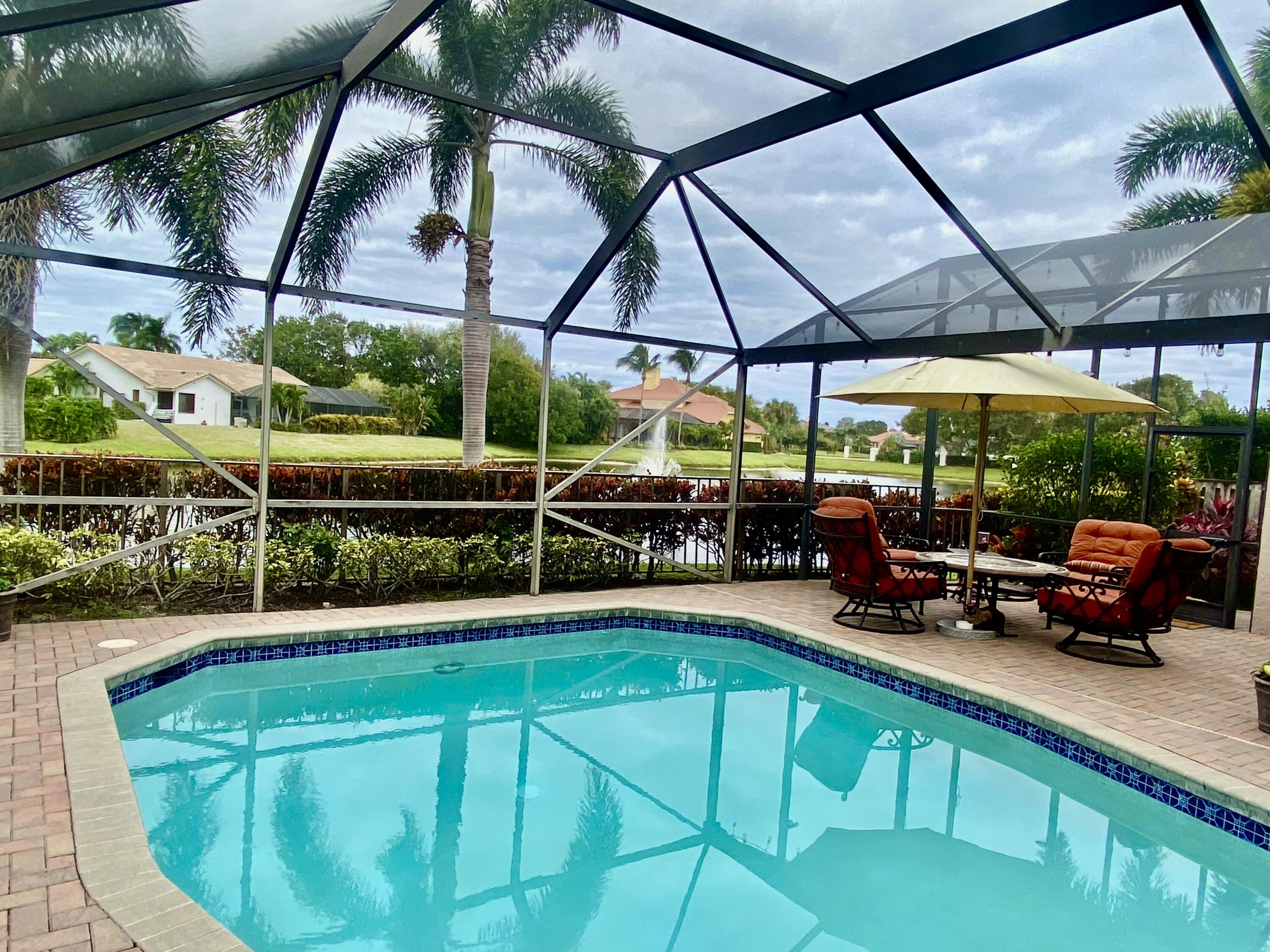 a view of a backyard with table and chairs under an umbrella