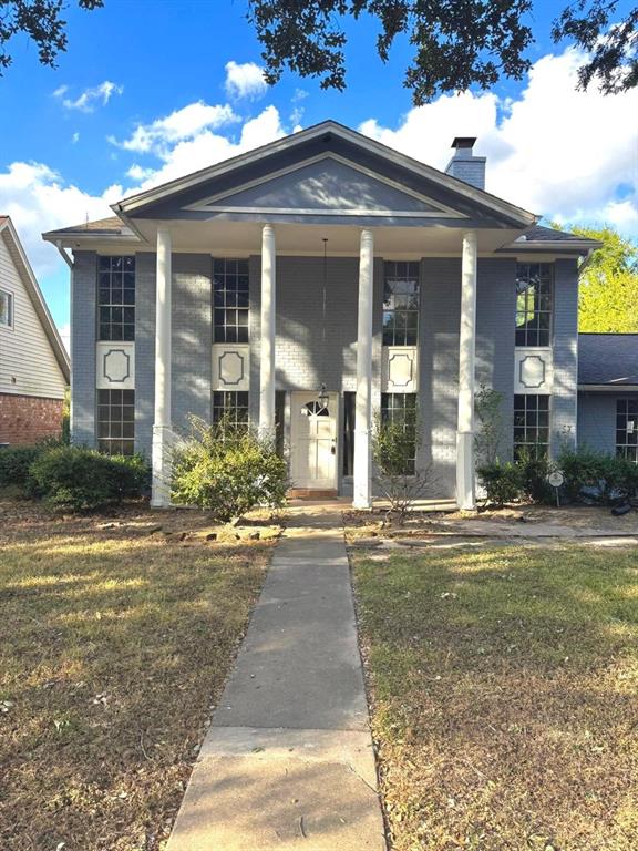 front view of a brick house with a yard