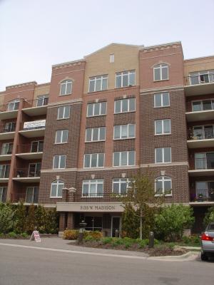 a front view of a building with lot of cars