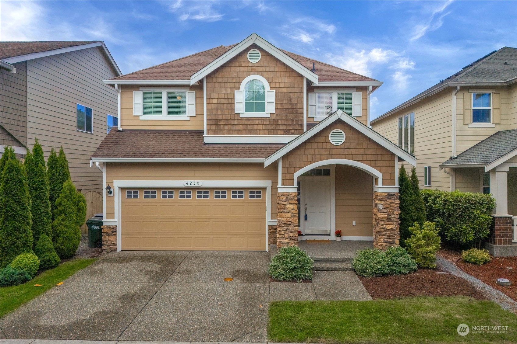 a front view of a house with yard and garage