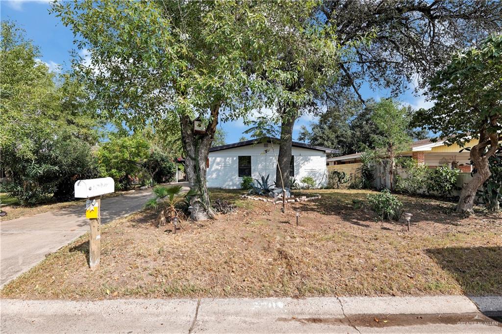 a front view of a house with a tree