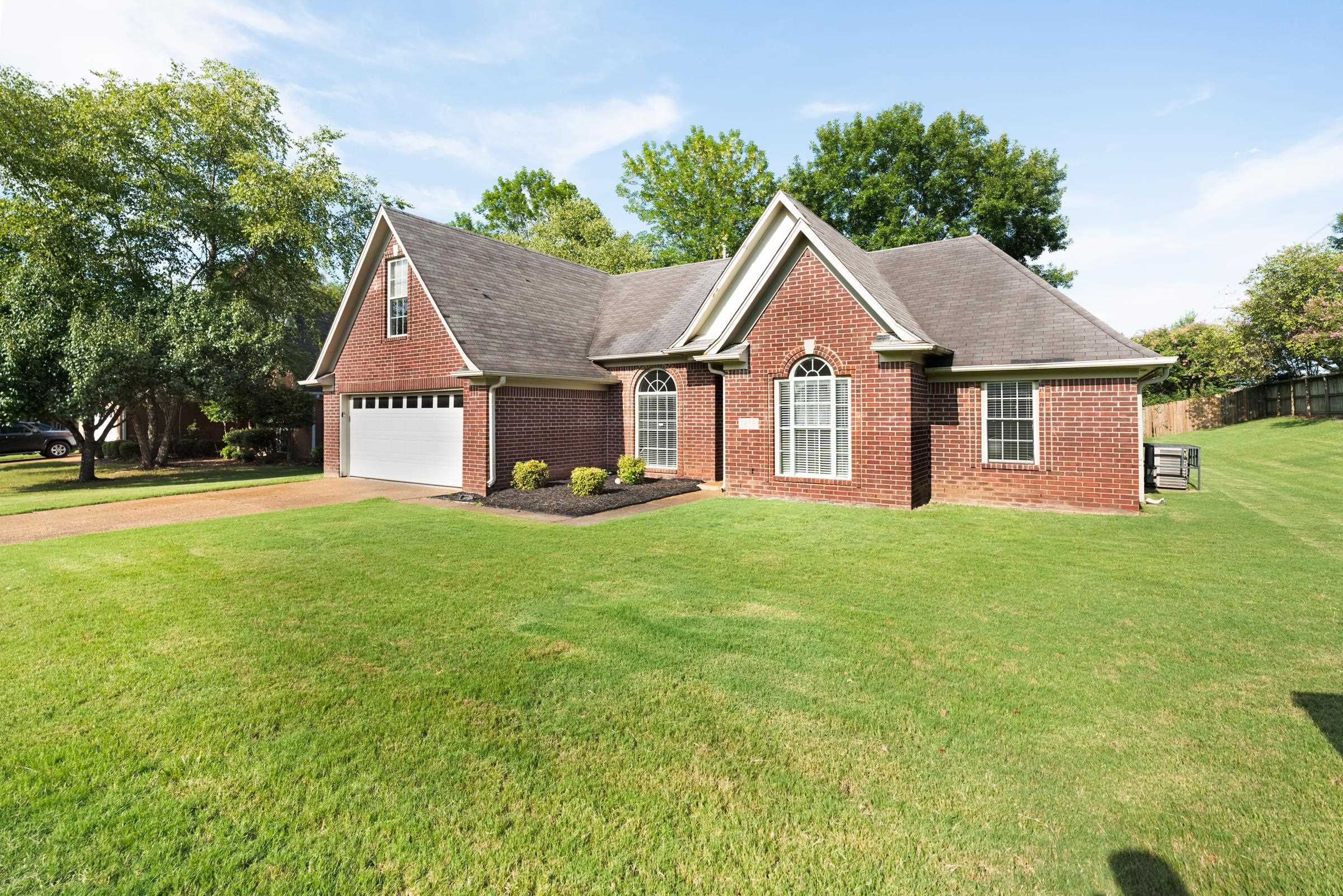 a front view of a house with a garden and yard