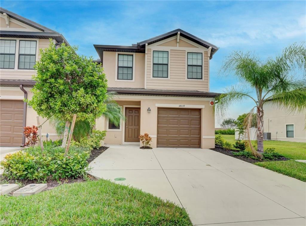 a front view of a house with a yard and garage