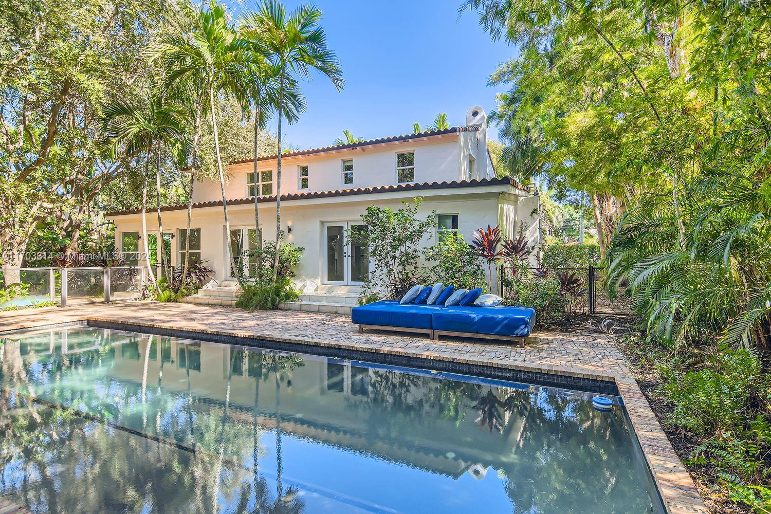 a view of a small white house with a swimming pool