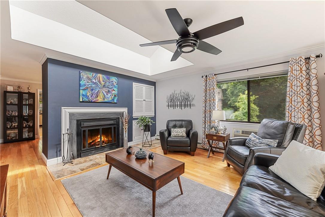 Living room featuring a fireplace, wood flooring and a skylight