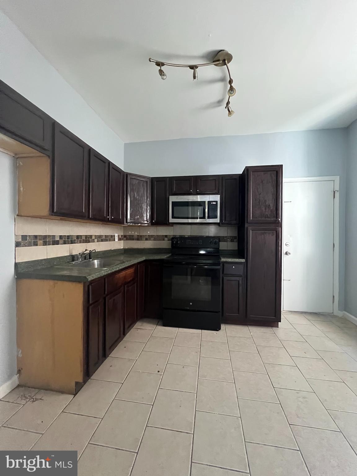 a kitchen with stainless steel appliances granite countertop a refrigerator and a stove