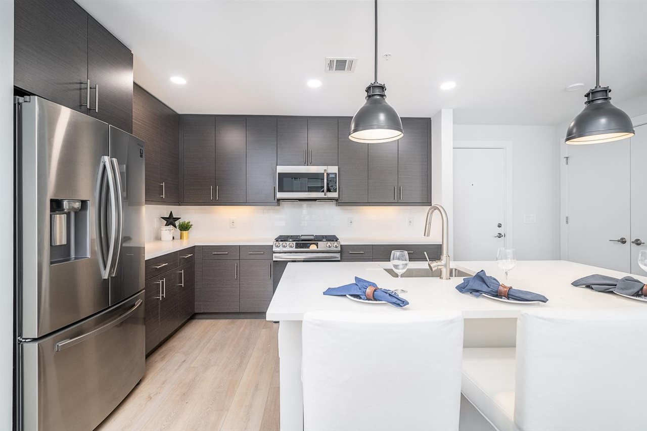 a kitchen that has a lot of cabinets a sink and appliances