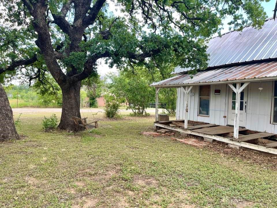 a view of a house with backyard and sitting area