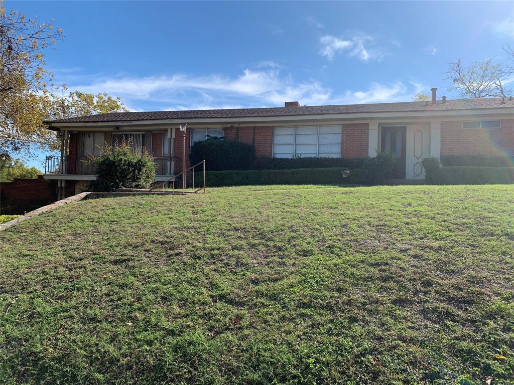 a view of house with yard and sitting area