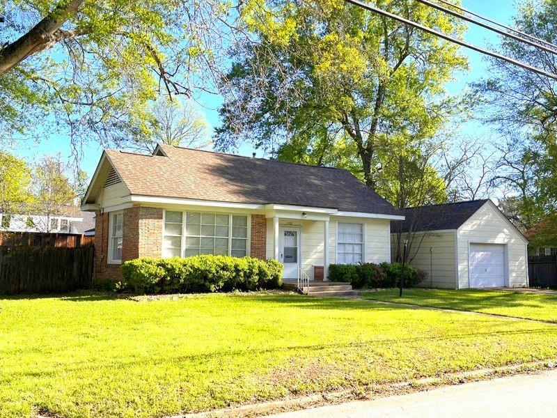 a front view of house with yard and trees around