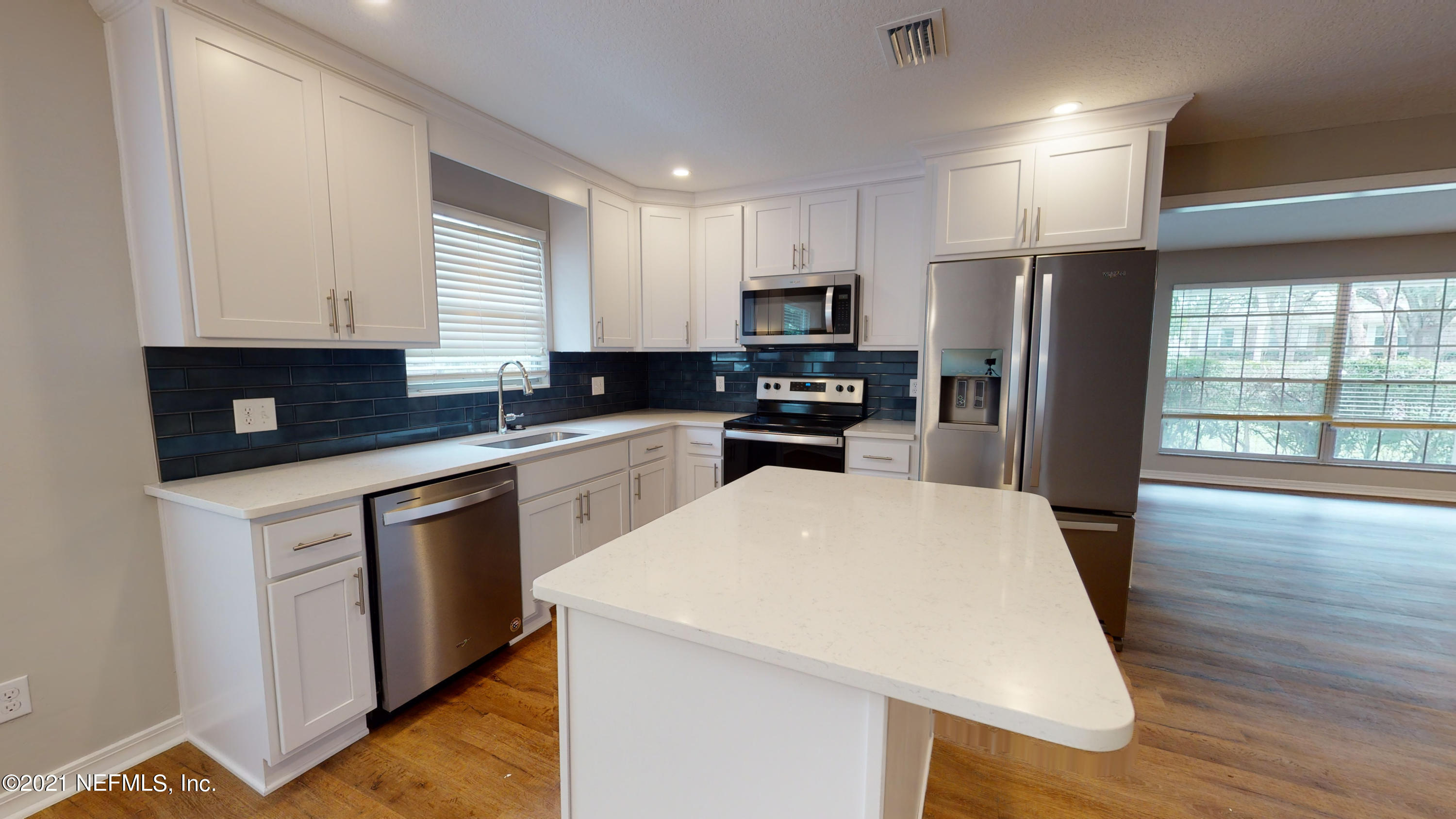 a kitchen with stainless steel appliances a refrigerator stove microwave sink and cabinets