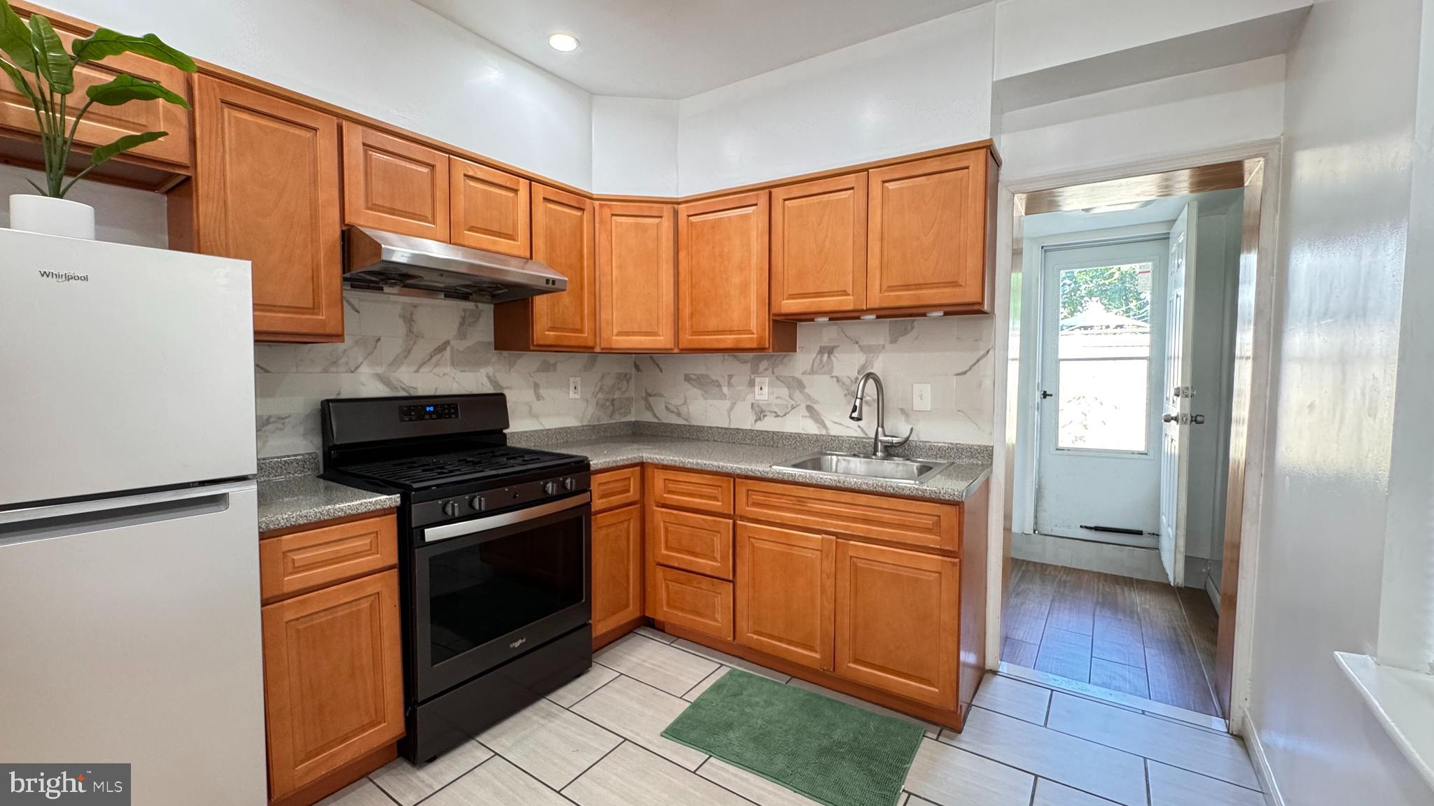 a kitchen with stainless steel appliances granite countertop a stove a refrigerator and a sink