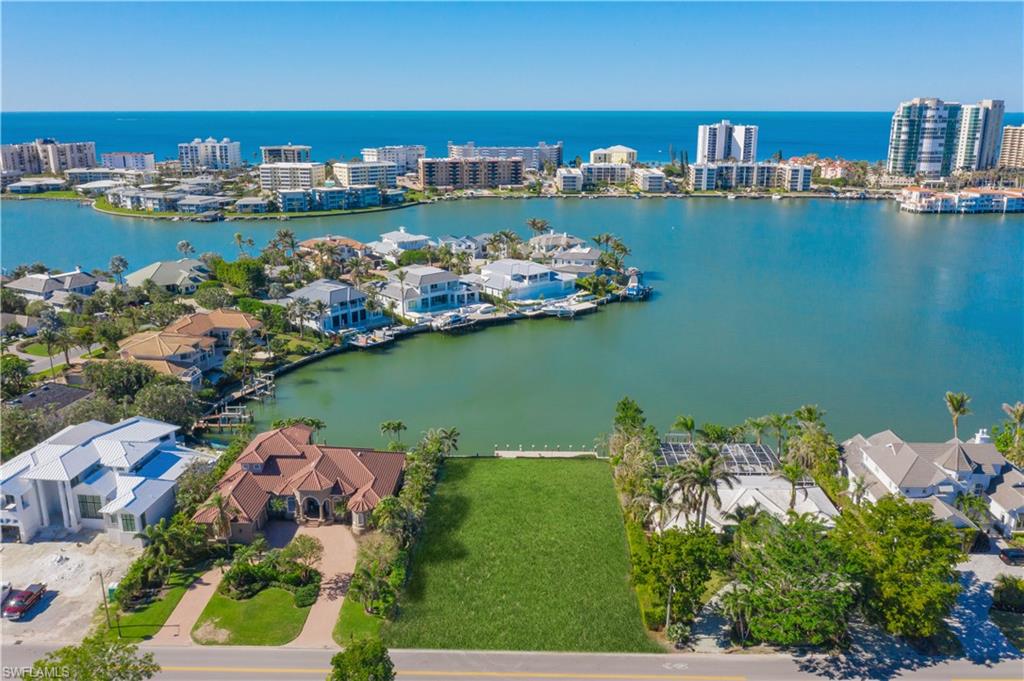 an aerial view of water body with boats and residential houses with outdoor space