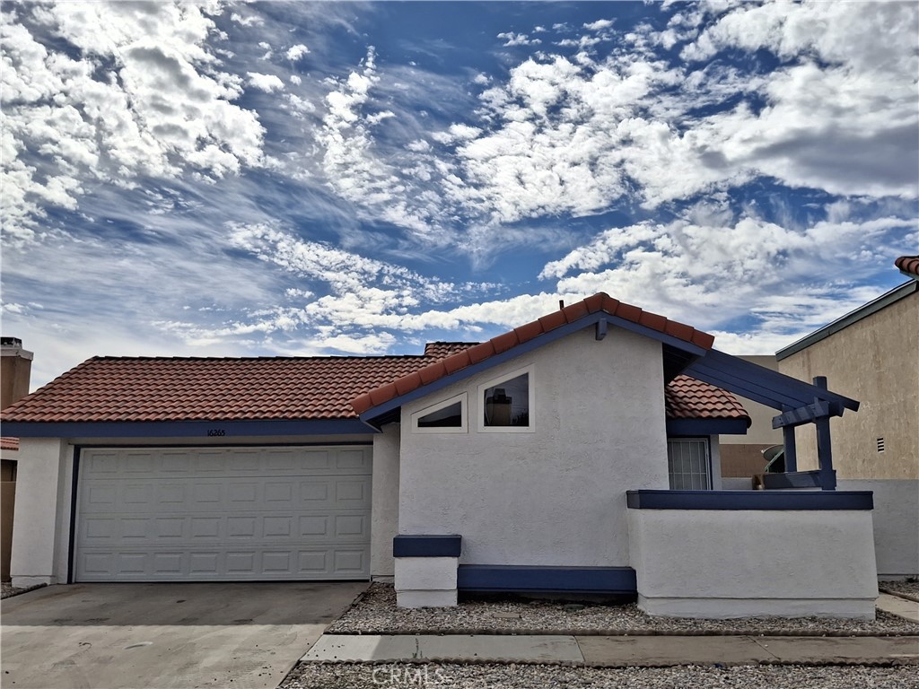 a front view of a house with a tree