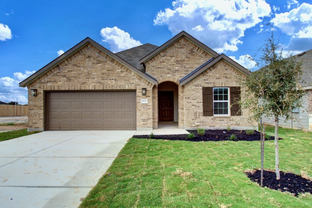 a front view of a house with a garden and yard