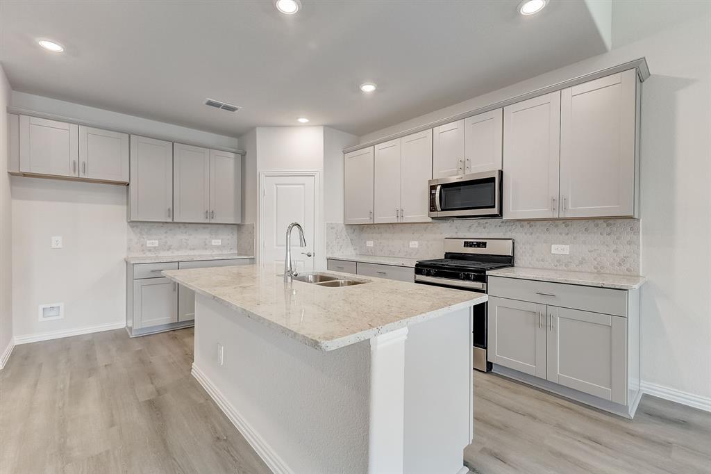 a kitchen with appliances a sink and cabinets