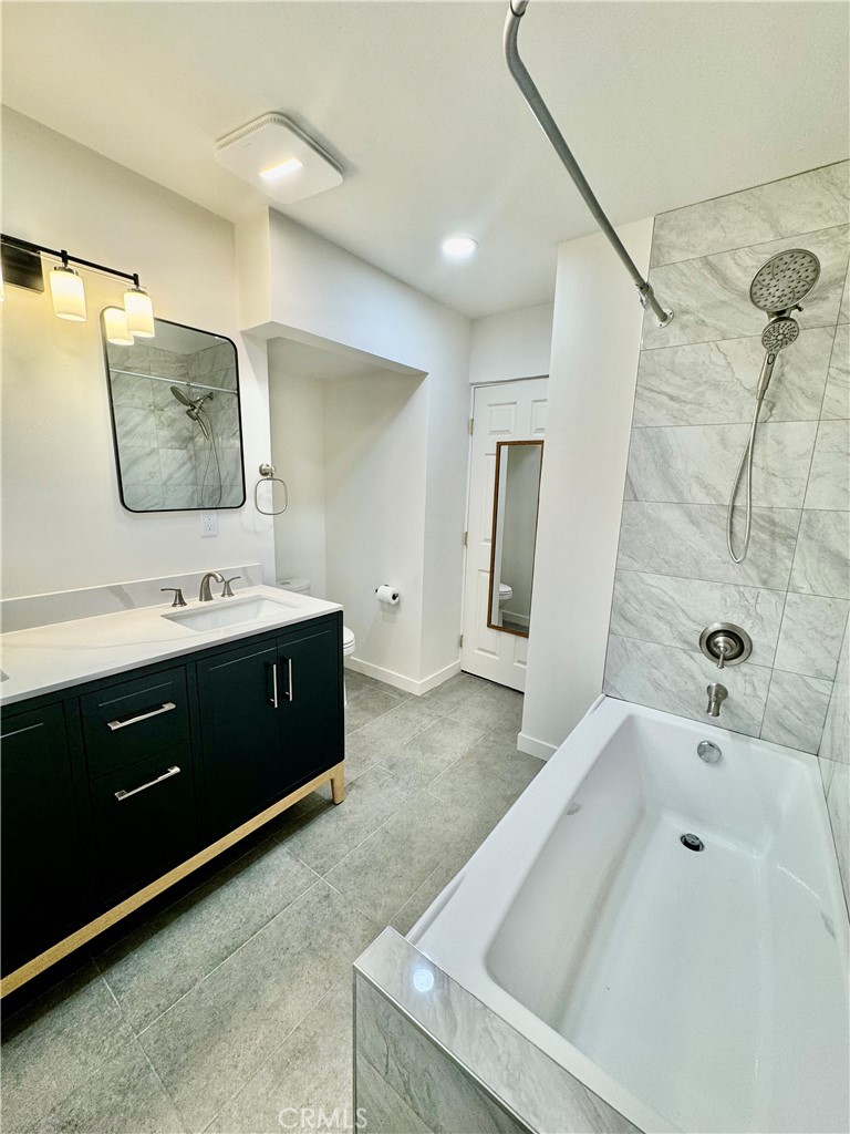 a spacious bathroom with a tub sink and mirror