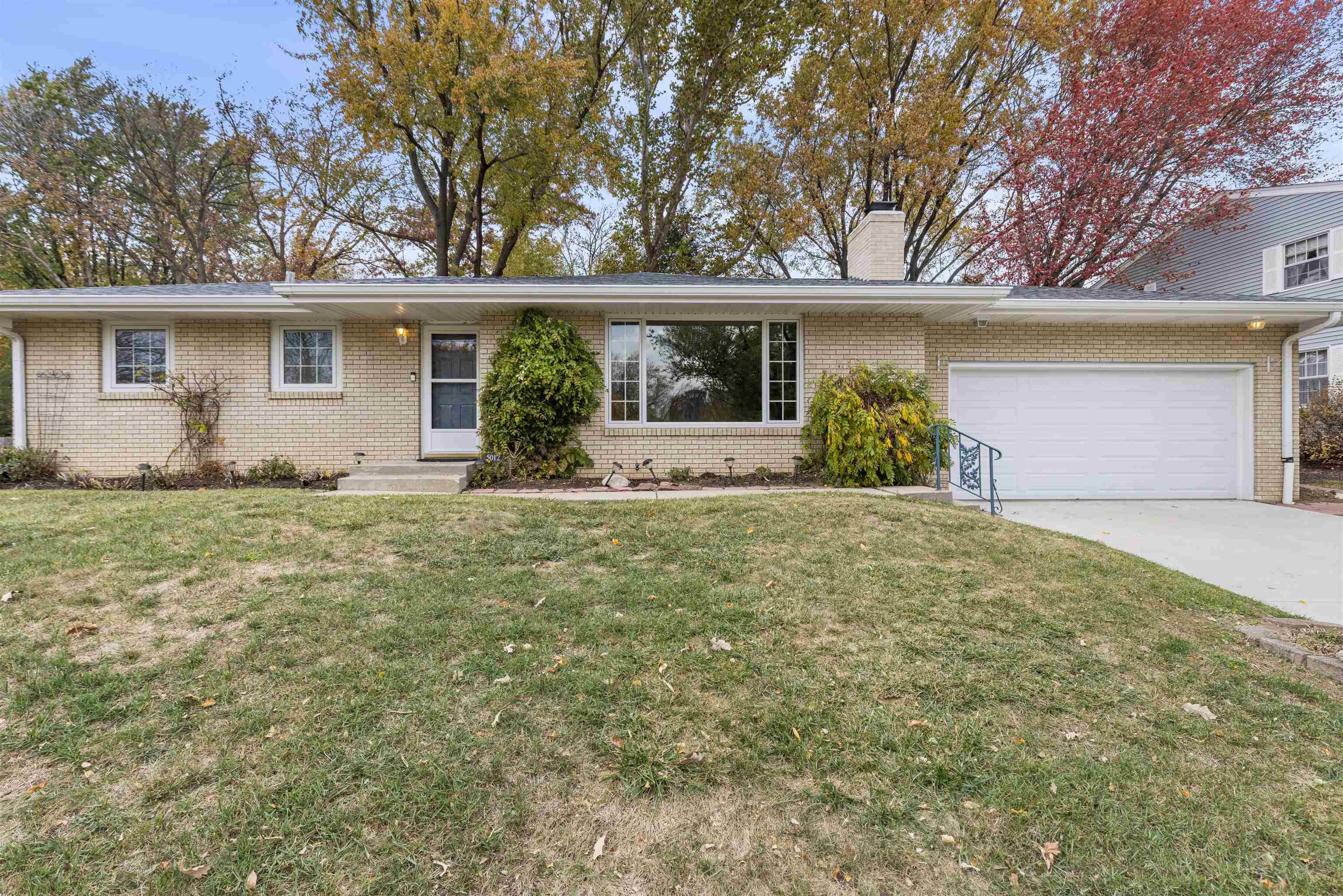 a front view of house with yard and trees around