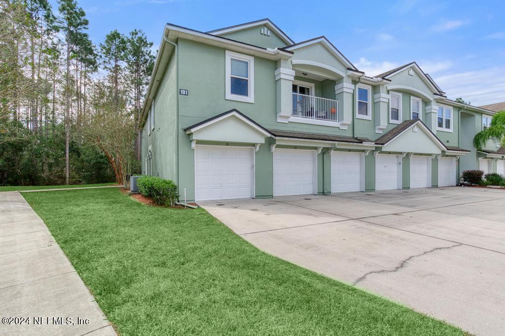 a front view of a house with a yard and trees