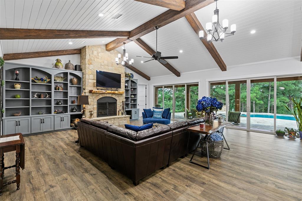 a living room with furniture a fireplace and a floor to ceiling window