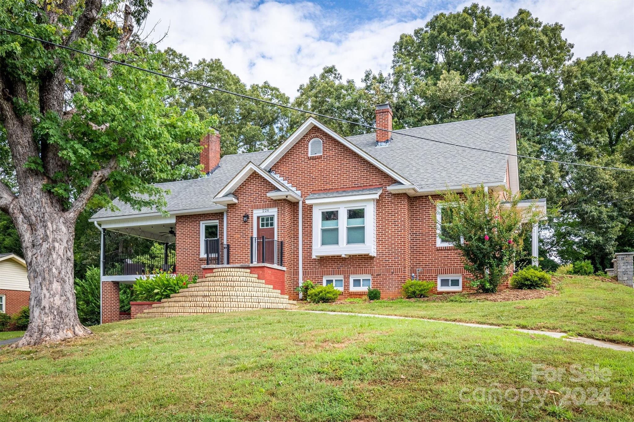 a front view of a house with a yard and trees