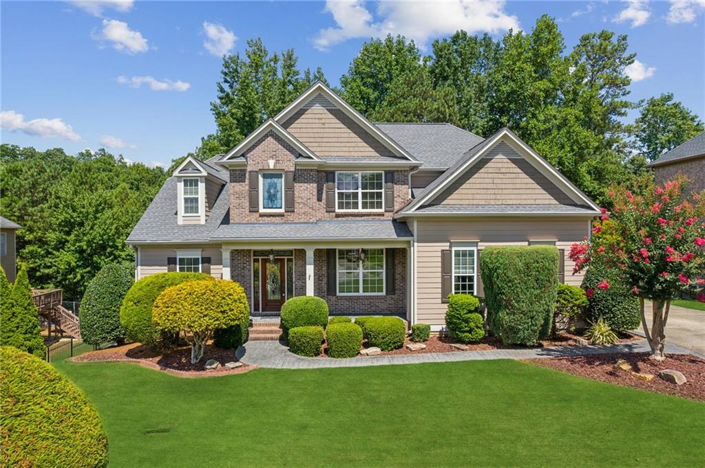 a front view of a house with a yard and green space