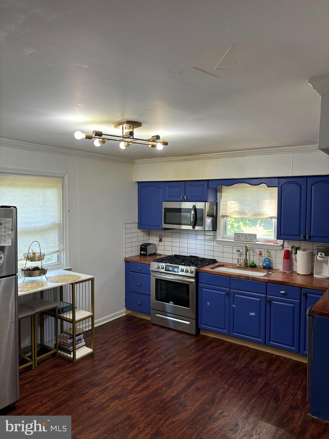 a large kitchen with stainless steel appliances granite countertop a stove and a view of living room