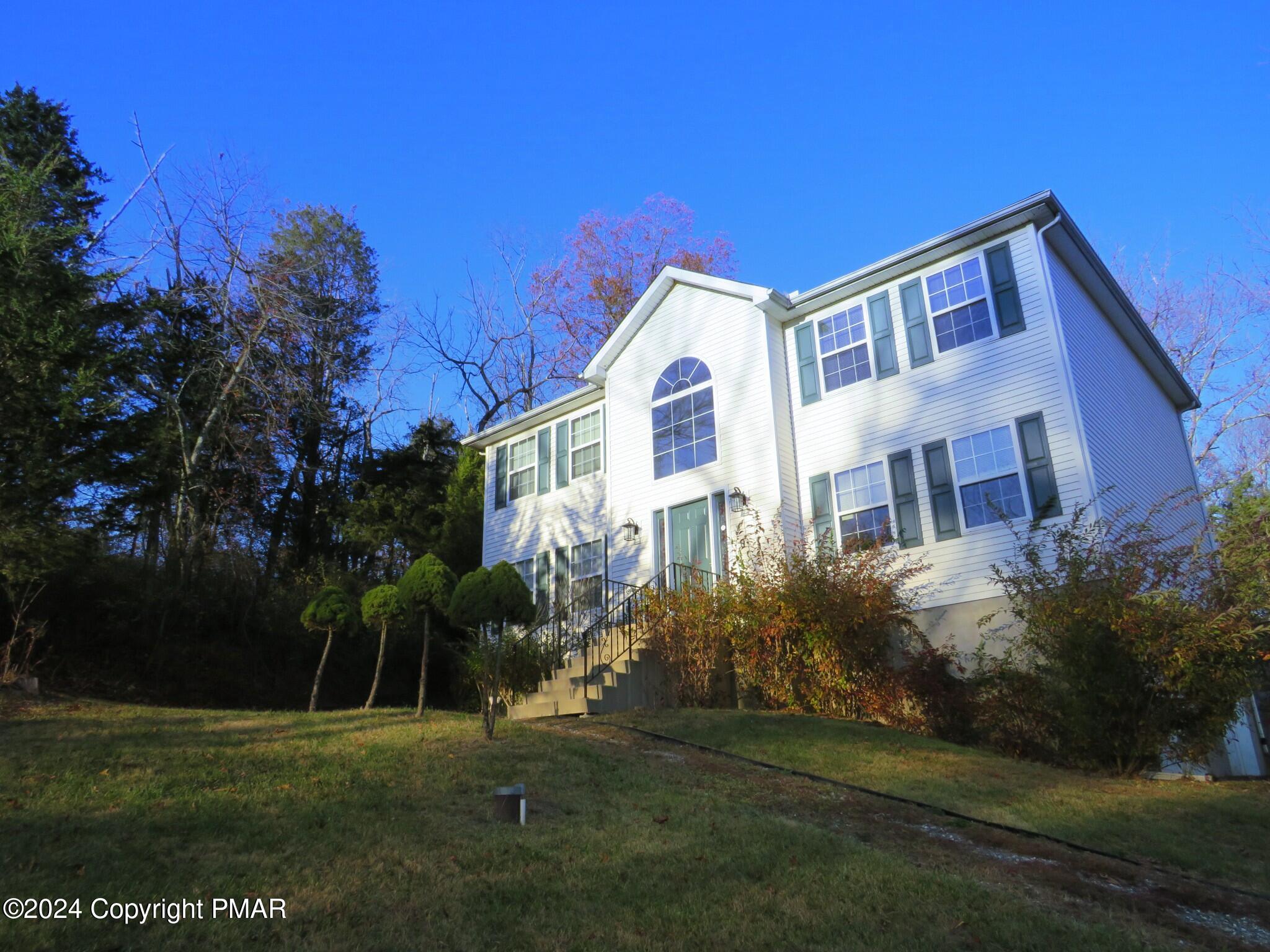 a front view of house with yard and green space