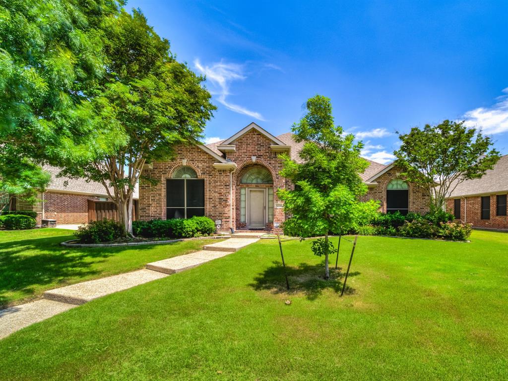 a front view of a house with a yard and trees