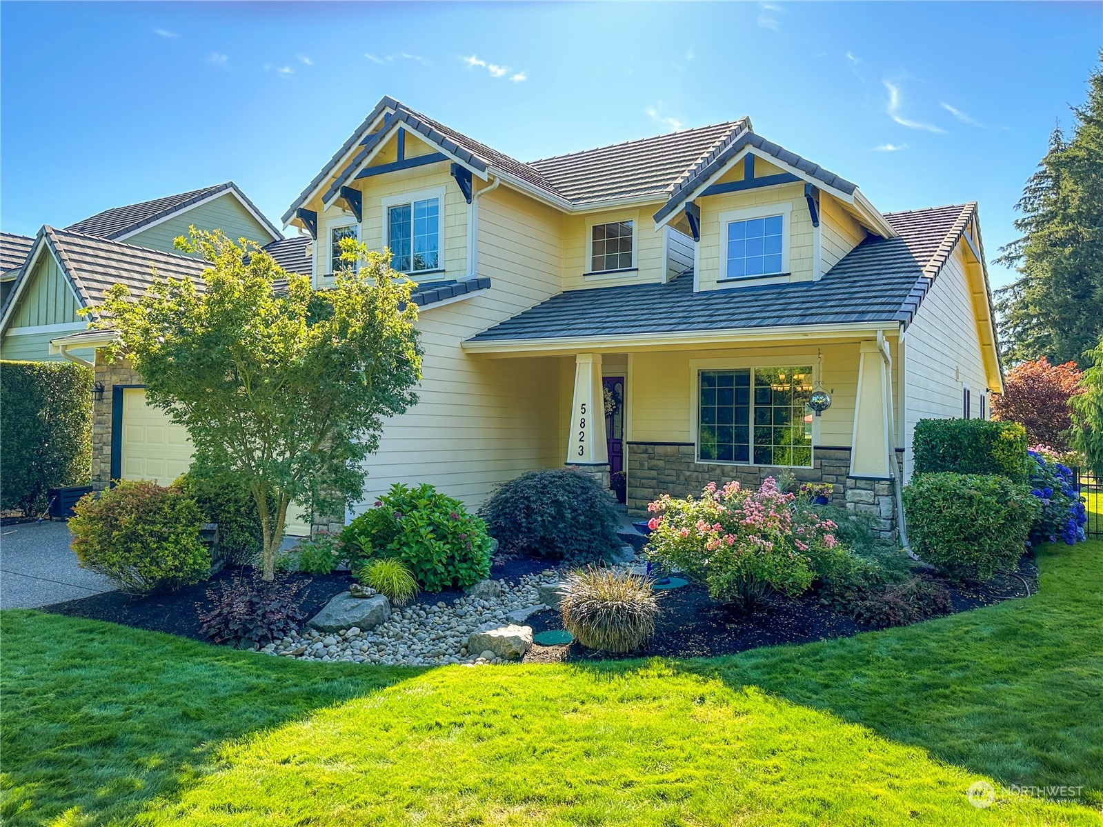 a front view of a house with a garden and plants