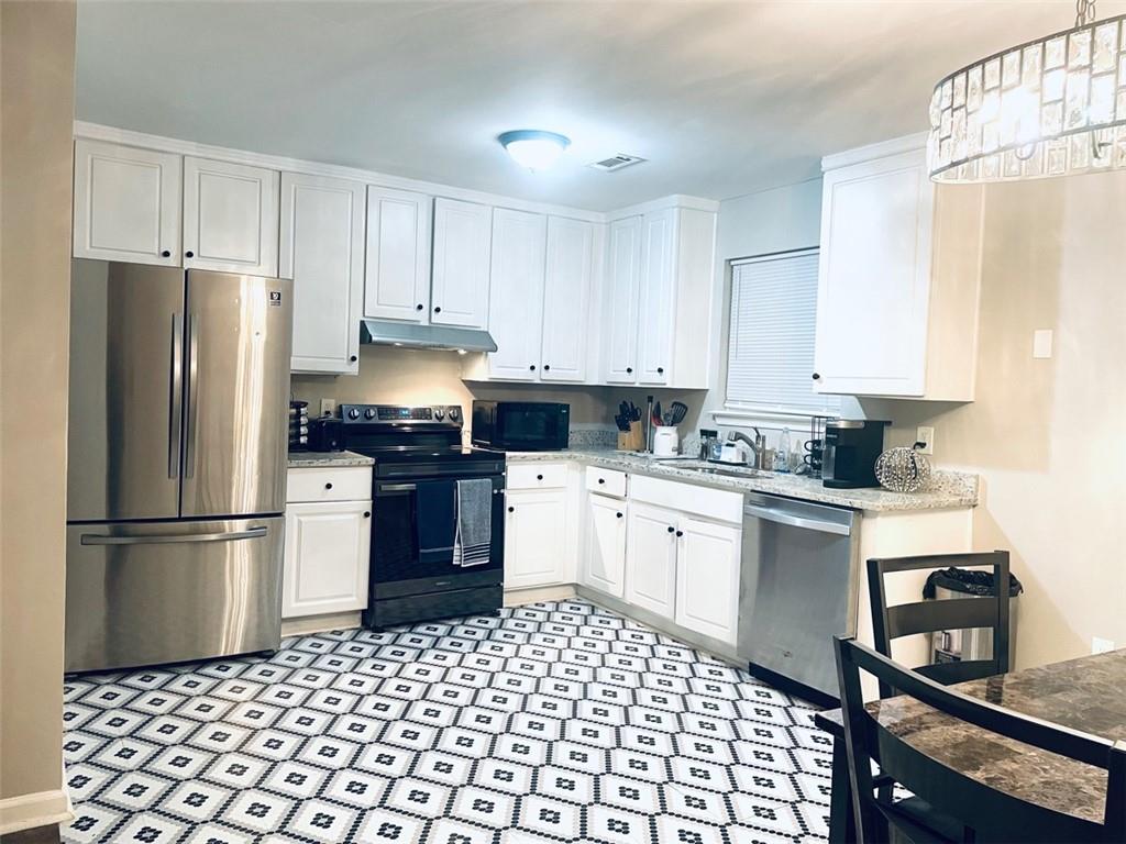 a kitchen with a refrigerator stove and white cabinets