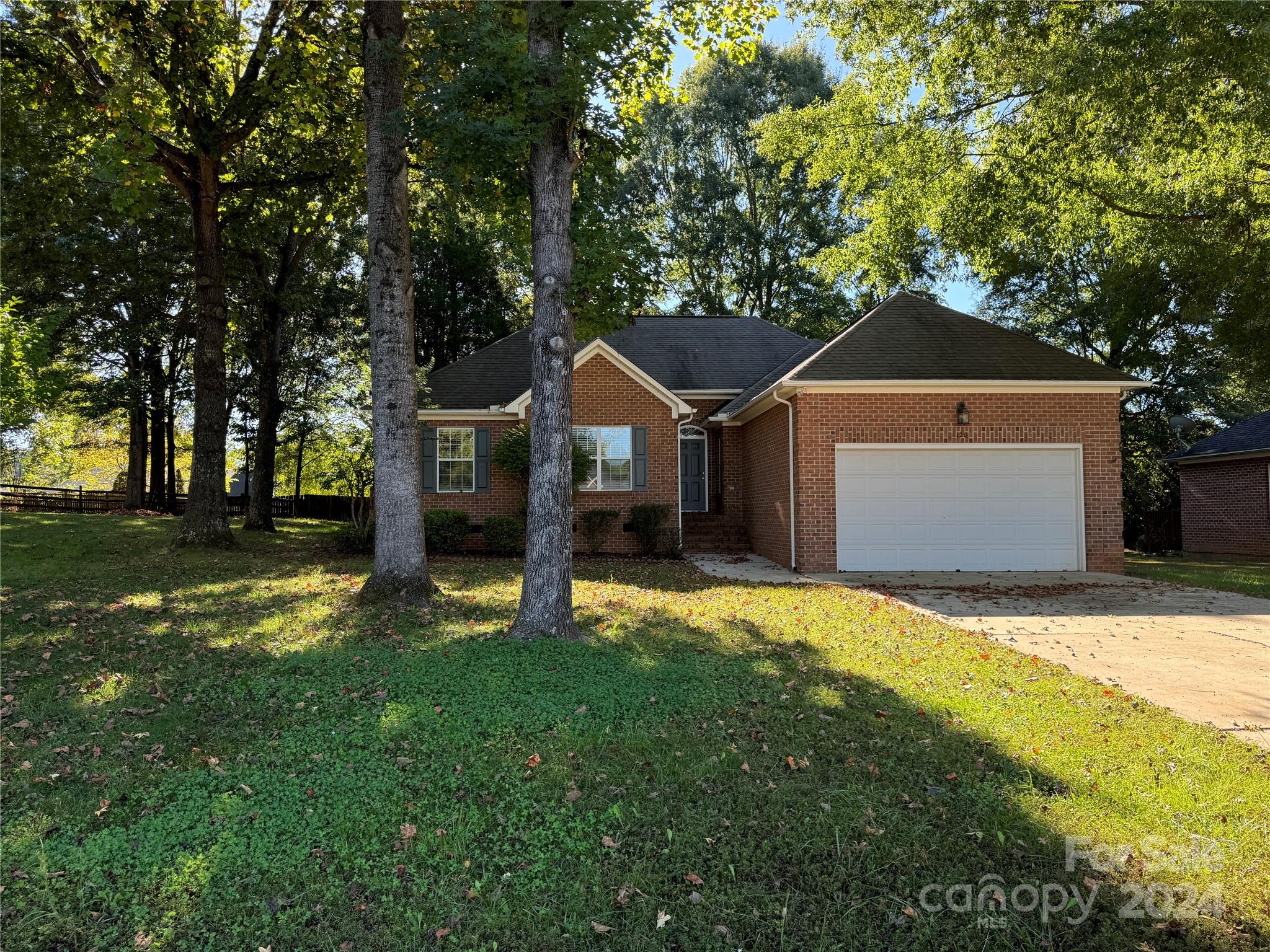 a front view of a house with a yard garage and trees