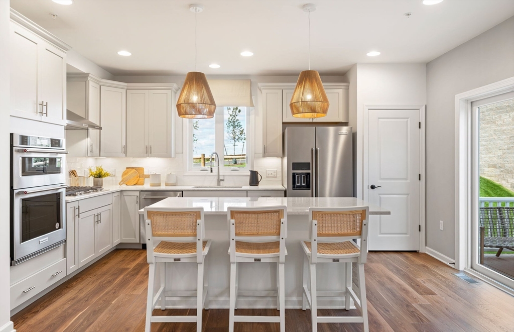 a kitchen with cabinets a sink stainless steel appliances and window