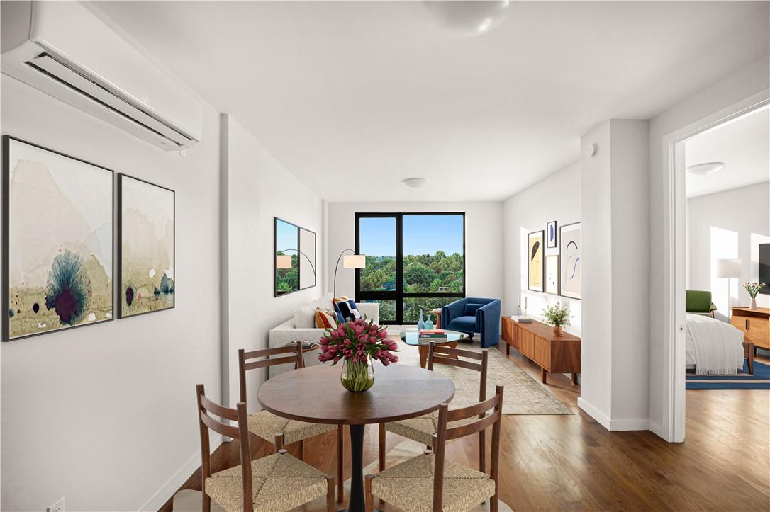 Dining area featuring an AC wall unit and hardwood / wood-style floors