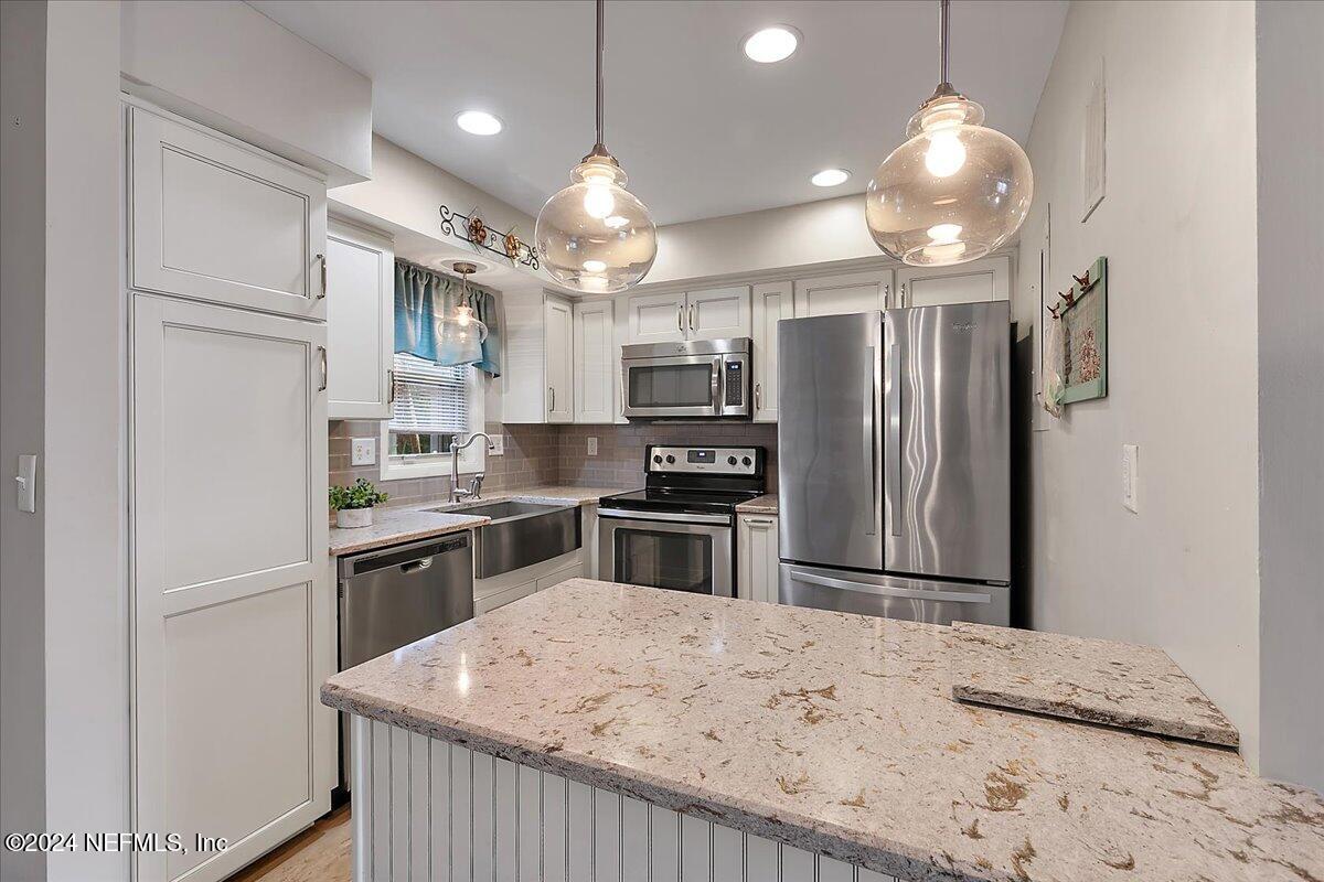 a kitchen with kitchen island a refrigerator sink stove and microwave